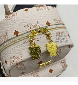Detail of smooth golden panda zipper on pink printed leather backpack with THE ONE pattern
