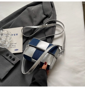 Close-up of woven denim and silver leather crossbody bag with adjustable strap