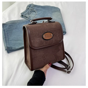 Close-up of brown suede vintage backpack showing textured flap and NICE FASHION logo