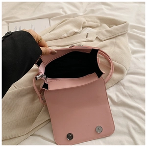 Détail intérieur du sac bandoulière rose clair avec compartiment zippé et boucles magnétiques