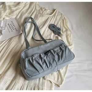 Detail of light blue pleated shoulder bag with adjustable drawstring and spare strap