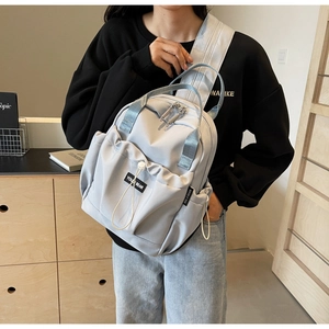 Detailed view of lightweight light blue nylon backpack with front drawstring pocket