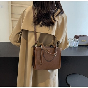 Braune Handtasche aus Leder mit Litschi-Struktur und goldenen Details im Streetstyle