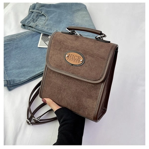 Detail of vintage brown suede crossbody bag featuring Nice Fashion metal logo plaque