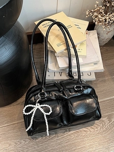 Glossy black Boston bag with pearl bow pendant and front utility pockets