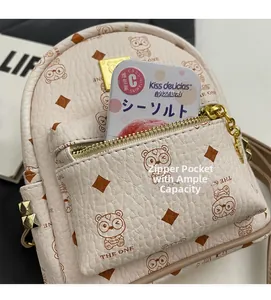 Close-up of front zipper pocket on cream leather backpack with cute bear pattern