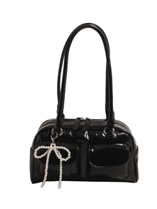 Glossy black Boston bag with dual front pockets and pearl bow charm accessory
