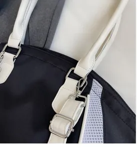 Detail of high-quality silver metal hardware and breathable white mesh on tote bag