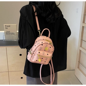 Pink mini leather backpack featuring cartoon bear prints and gold bear pendant detail