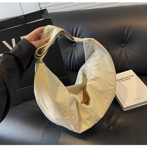 Detail of beige nylon crescent bag with textured fabric and leather zipper puller