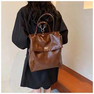 Brown vintage leather backpack with stitching detail and silver twist lock shown on model