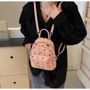 Pink mini backpack detail with bear patterns, metal logo plate and chain decoration