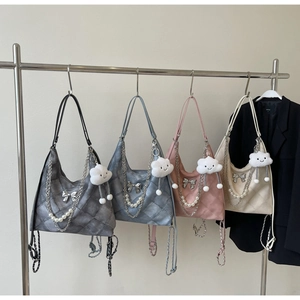 Detail of quilted tote bags with metallic bow and pearl chain in four soft colors