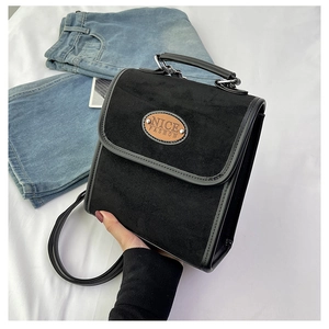 Detail of vintage black faux suede handbag showing the NICE FASHION logo and top handle