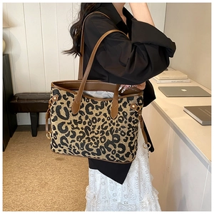 Detailed view of leopard print tote bag with brown leather handles and large capacity