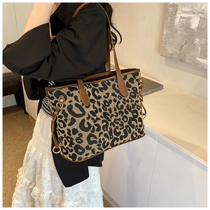 Close-up of leopard print tote bag texture with leather handle and metal hardware detail