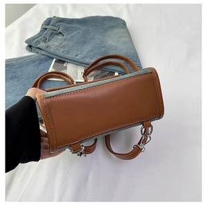 Close-up of vintage suede backpack showing leather stitching and metal chain details