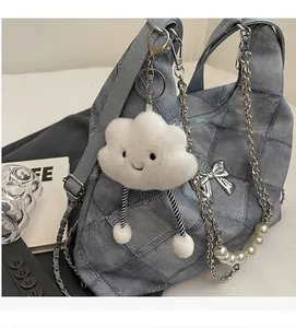 Detail of denim texture tote with silver bow and pearl chain strap decoration
