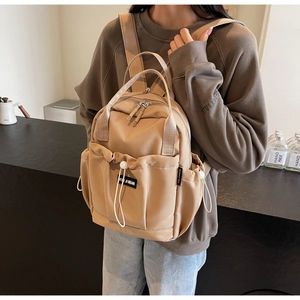 Detail of durable nylon travel backpack with drawstring pocket and silver metal zippers