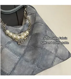 Close-up of gray denim tote featuring quilted pattern and pearl bow chain detail