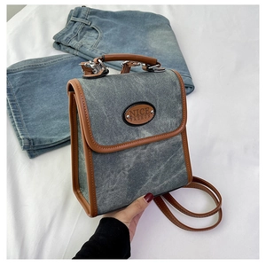 Detail of vintage denim small backpack showing retro leather trim and nice fashion logo