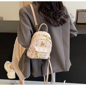 Mini pink backpack featuring bear monogram print and gold hardware shown on model