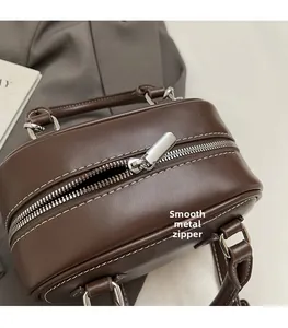 Close-up of smooth silver metal zipper and brown leather texture on bowling bag