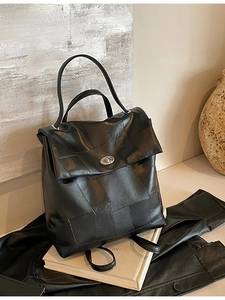 Modern black leather patchwork backpack with silver metal buckle in a stylish setup