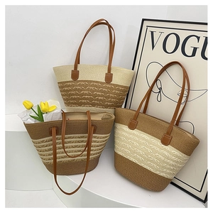Detail of three large striped straw tote bags with leather handles for beach vacation