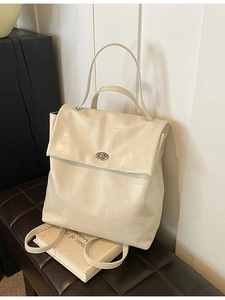 Minimalist cream white backpack with geometric quilted pattern and silver swivel lock