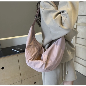 Detailed shot of large mauve nylon crescent bag with adjustable wide shoulder strap