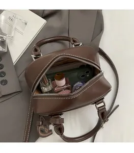 Top view showing the internal capacity of the brown leather mini bowling bag with daily items