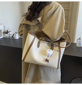 Borsa tote crema portata a spalla con bordi marroni e trama in pelle martellata
