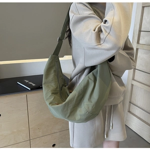 Detailed side view of large olive nylon crescent crossbody bag with adjustable wide strap