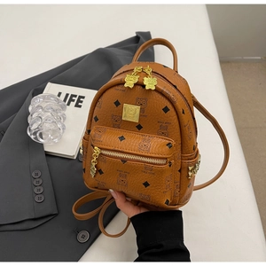 Close-up of brown mini backpack with bear patterns and golden hardware accents
