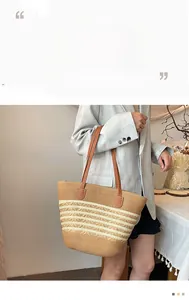 Detail of striped woven straw tote bag featuring brown leather shoulder straps and stitching