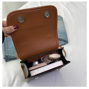 Detail view of the suede crossbody bag interior with dual magnetic snap closure
