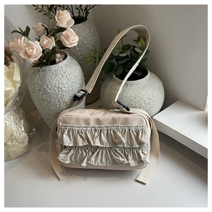 Detail der cremeweißen Schultertasche mit Rüschen und Falten aus leichtem Nylon
