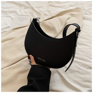 Détail du sac demi-lune noir avec poignée en foulard de soie et anneaux en métal argenté