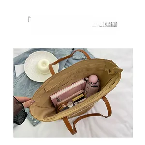 Macro view showing large capacity interior of straw tote bag with brown leather handles