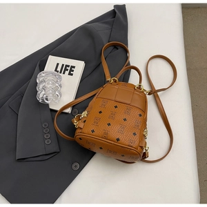 Detail of caramel brown backpack with bear pattern and golden metal buckles on grey suit