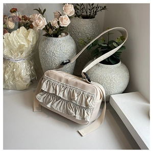 Detail der beigen Nylon-Schultertasche mit Rüschen und verstellbarem Riemen im Alltag