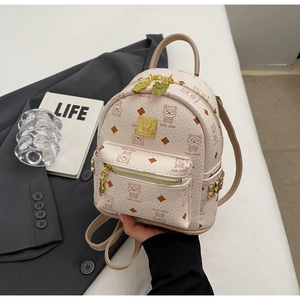 Detail of beige textured leather backpack with cartoon bear prints and gold studs