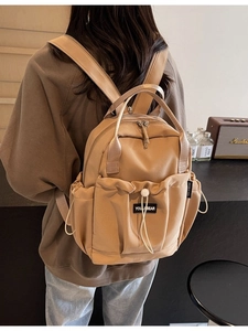 Minimalist khaki nylon backpack for women featuring a large drawstring front pocket