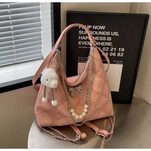 Detail of pink quilted tote bag with silver bow ornament and pearl chain decoration