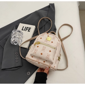 Detail of a cream mini backpack with cartoon bear print and golden studs on a blazer