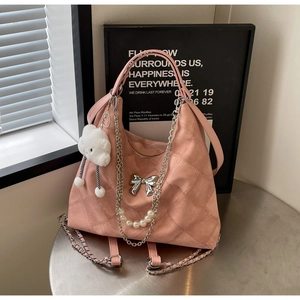 Detailed macro of pink quilted tote bag with silver bow chain and pearl bead charms