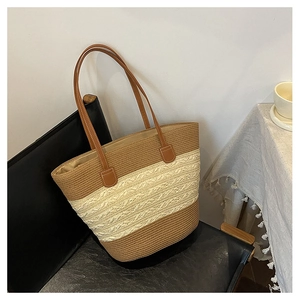 Macro view of woven tote bag with brown leather handles and striped texture