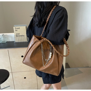 Brown leather tote bag featuring a woven handle with pearl and silver chain detail