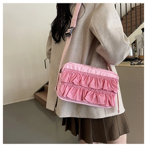 Detailsicht einer rosa Umhängetasche mit gerafften Kanten und breitem Gurtband